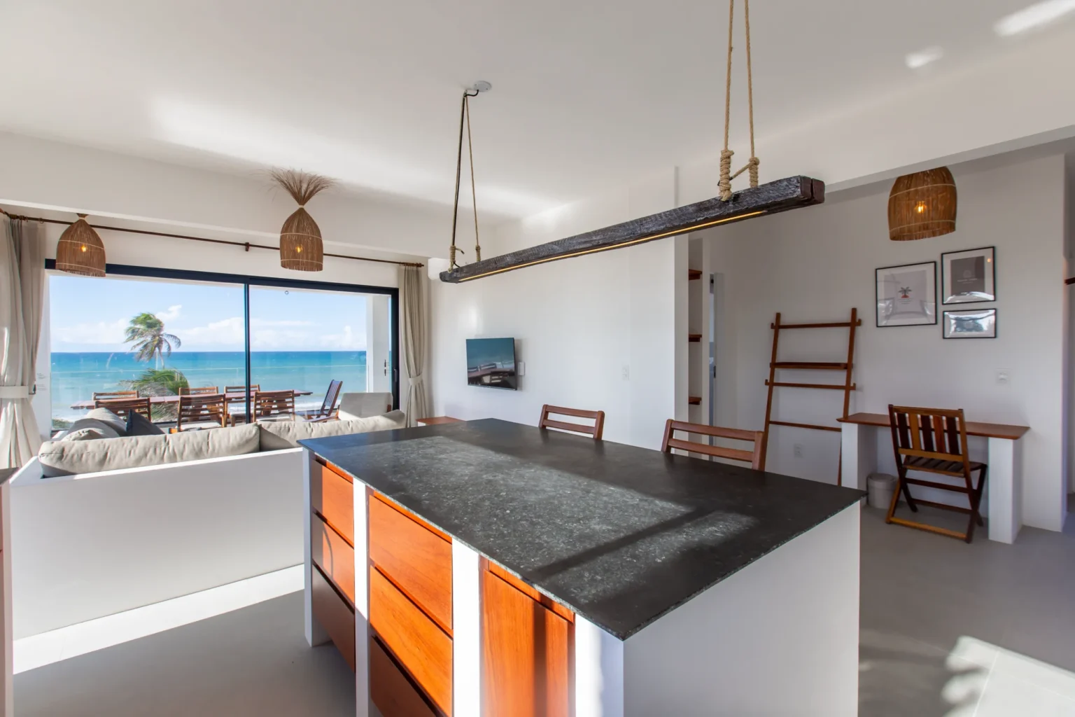 Open-plan kitchen and living area with an ocean view in a beachfront apartment at Windtown Cumbuco