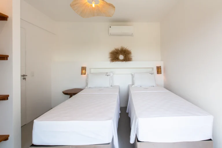 Second bedroom of a two-bedroom apartment at Windtown Cumbuco, set up with two single beds